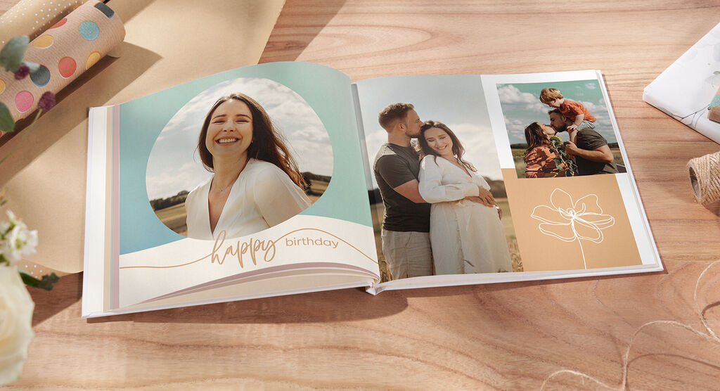 Un album fotografico aperto con due immagini affettuose, un messaggio di compleanno e un design floreale.