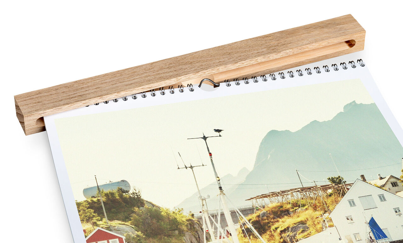 Calendario CEWE mostra paesaggio costiero con montagne visibili sullo sfondo.