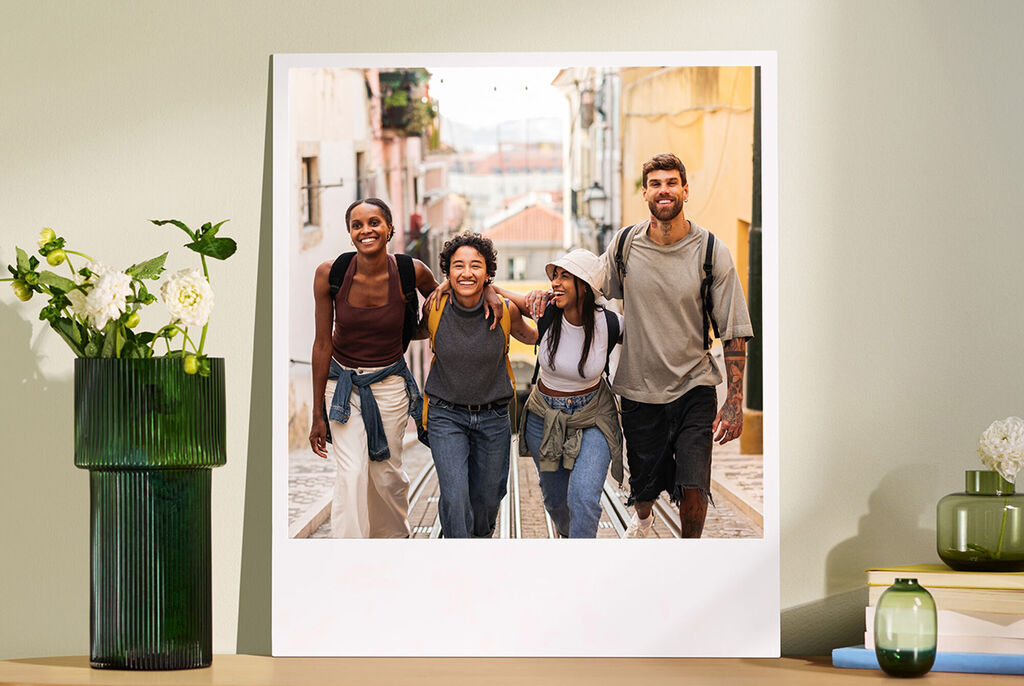 Un gruppo allegro di quattro amici che passeggiano lungo una strada, divertendosi. Indossano abiti sportivi e sorridono.