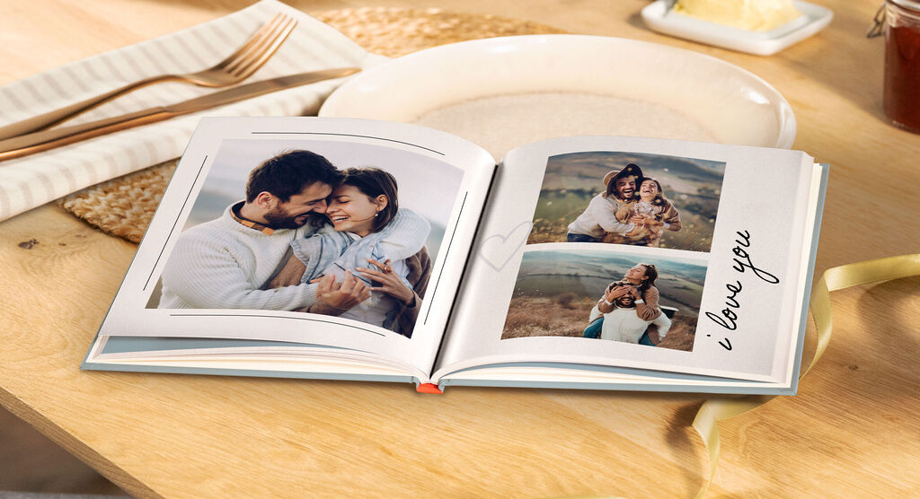 Un album fotografico aperto con immagini amorevoli di una coppia e una famiglia. Il testo "Ti amo" vicino a una foto.