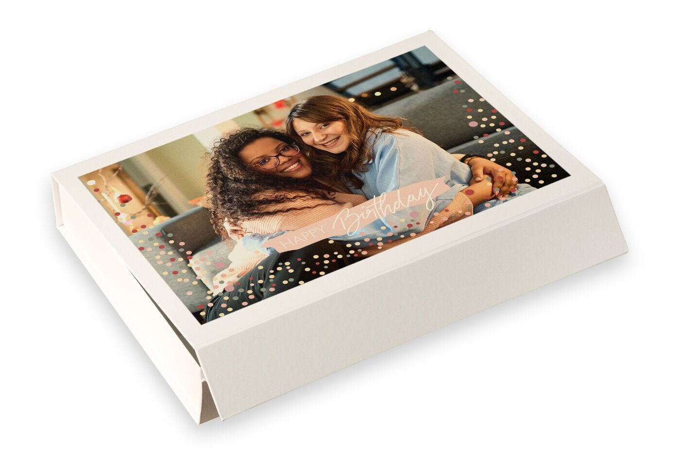 Due donne si abbracciano felici nel soggiorno con decorazioni colorate per un compleanno.