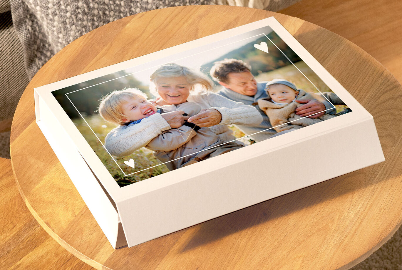 Una famiglia affettuosa che guarda un album foto CEWE su una superficie di legno accogliente
