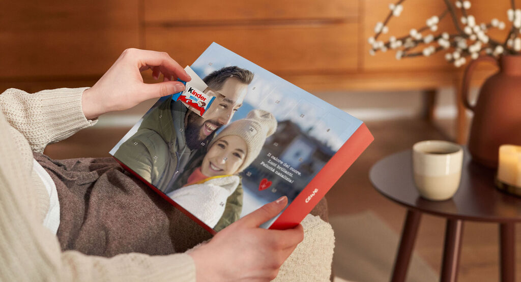 Una persona sfoglia un libro foto CEWE sui ricordi di vacanza.