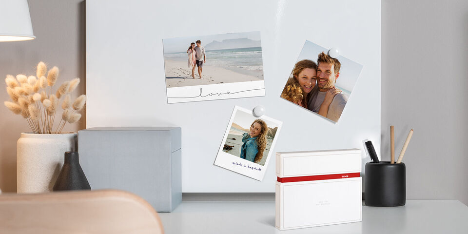 Due cartoline fotografiche su una superficie chiara, un bel album fotografico e elementi decorativi.