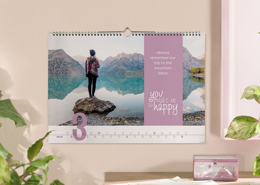Una persona su una roccia vicino al lago guarda le montagne. Il calendario ricorda un'escursione.
