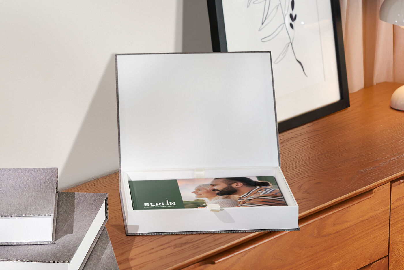 Bellissimo CEWE Fotolibro in una scatola regalo aperta su un tavolo di legno