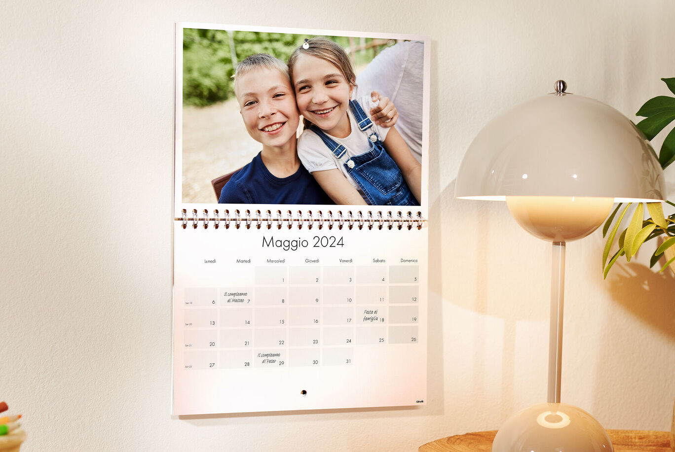 Calendario con un bambino sorridente e un adulto sullo sfondo.